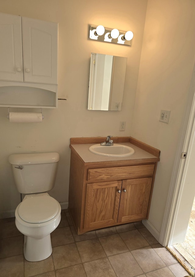 bathroom featuring baseboards, vanity, and toilet