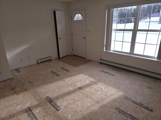 foyer entrance with baseboard heating and baseboards