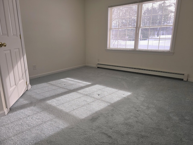 empty room featuring a baseboard heating unit and light carpet