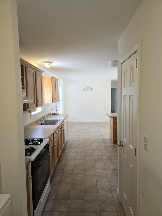 kitchen featuring range hood, pendant lighting, light countertops, gas stove, and a sink