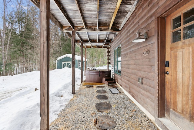 exterior space with an outdoor structure, a hot tub, and a storage shed