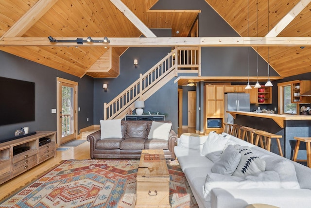 living room with light wood-type flooring, wooden ceiling, beam ceiling, and stairs