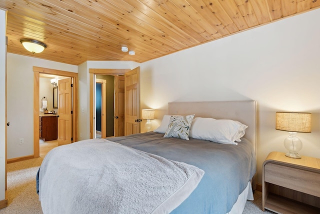 bedroom with baseboards, wood ceiling, and light colored carpet