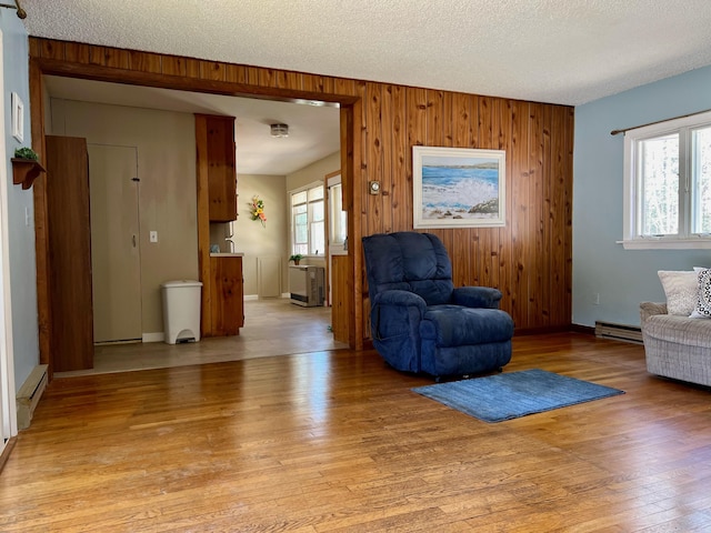 living area with light wood finished floors, wooden walls, and a wealth of natural light