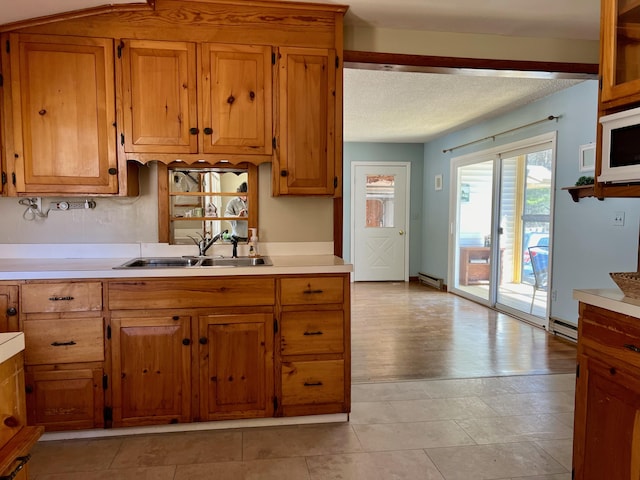 kitchen with brown cabinets, light countertops, and a sink