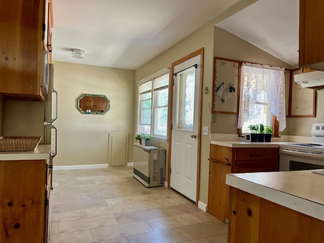 kitchen with light countertops, white range with electric cooktop, brown cabinetry, and under cabinet range hood