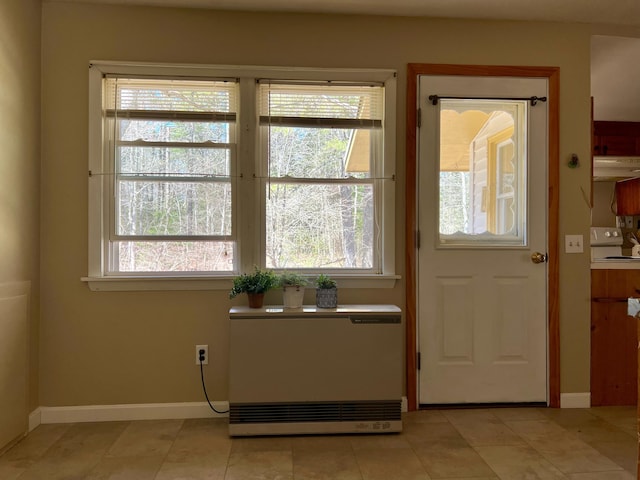 doorway with plenty of natural light and baseboards