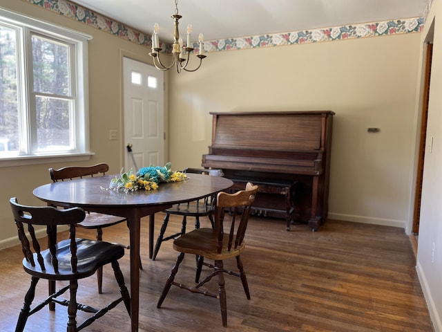 dining room with a chandelier, dark wood finished floors, and baseboards