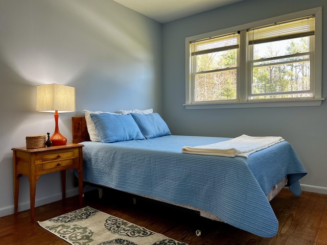 bedroom featuring baseboards and dark wood-style flooring