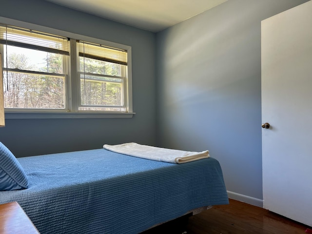 bedroom with dark wood-style floors and baseboards