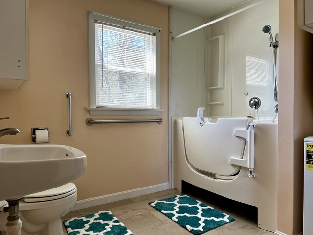 bathroom featuring toilet, a shower stall, baseboards, and tile patterned floors