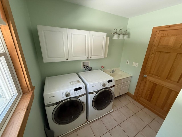 clothes washing area featuring cabinet space, a sink, washer and clothes dryer, and light tile patterned flooring