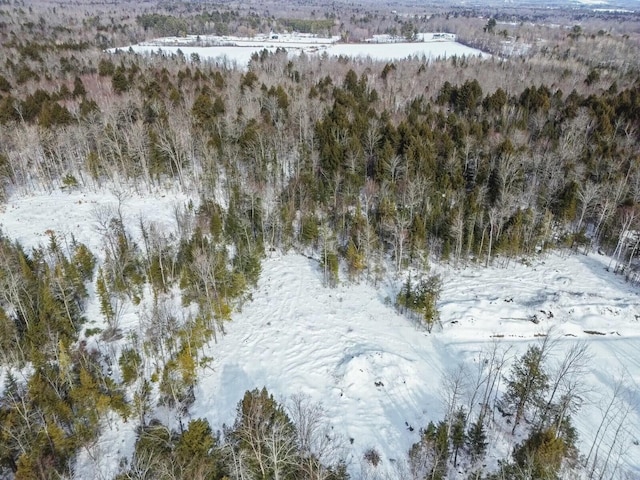 snowy aerial view with a wooded view