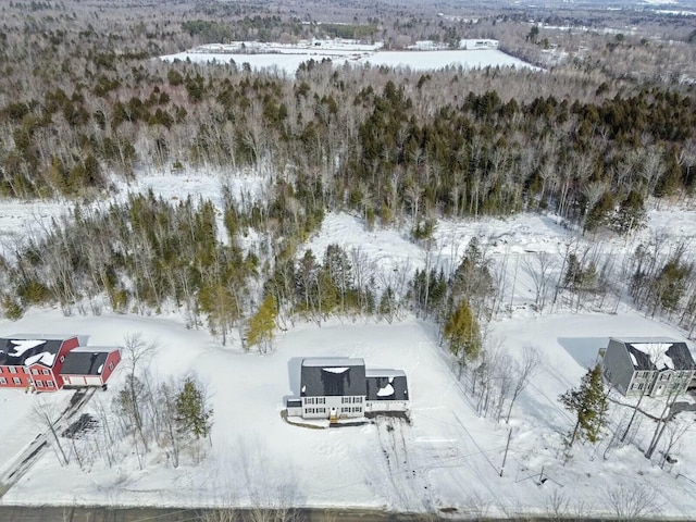 snowy aerial view with a wooded view