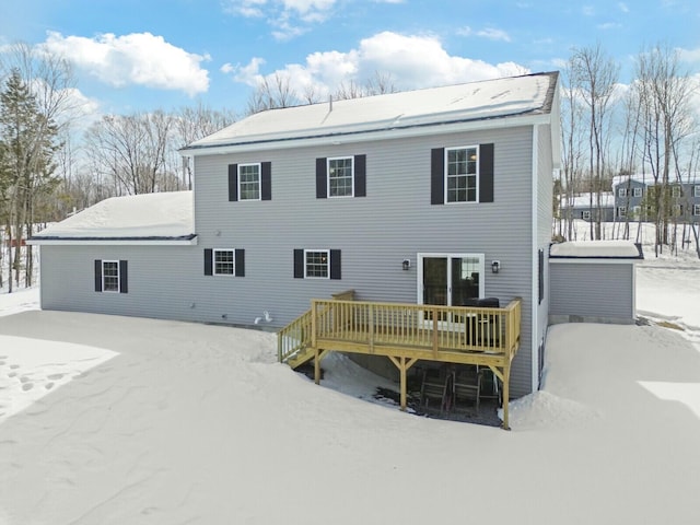 snow covered house featuring a wooden deck