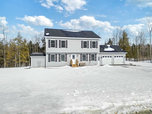 colonial house featuring a garage, a storage unit, and an outdoor structure