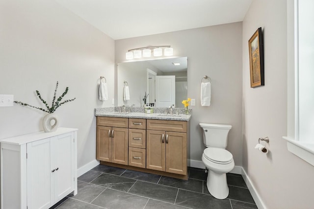 full bath featuring double vanity, tile patterned flooring, a sink, and toilet