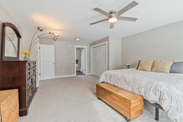 bedroom featuring light carpet, ceiling fan, baseboards, and a closet