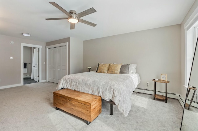 carpeted bedroom featuring a baseboard heating unit, a closet, a ceiling fan, and baseboards