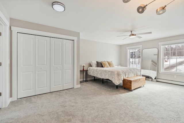 carpeted bedroom featuring a closet, multiple windows, and ceiling fan