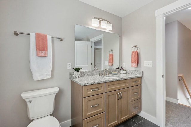 bathroom with vanity, toilet, and baseboards