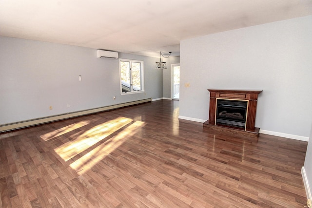 unfurnished living room with a baseboard radiator, a fireplace with raised hearth, an AC wall unit, wood finished floors, and baseboards