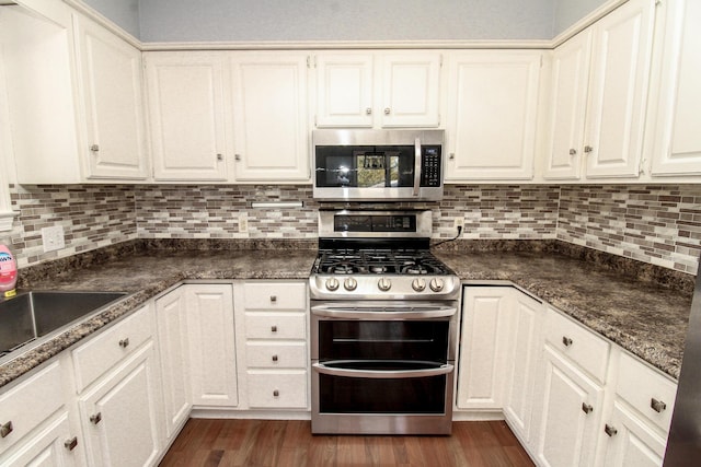 kitchen with stainless steel appliances, white cabinets, and dark wood finished floors