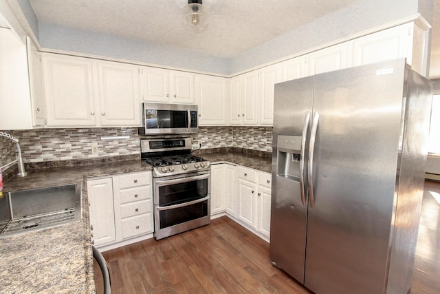 kitchen featuring appliances with stainless steel finishes, white cabinets, and a sink