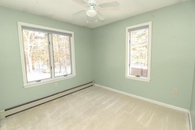 unfurnished room with a baseboard heating unit, a healthy amount of sunlight, light carpet, and baseboards