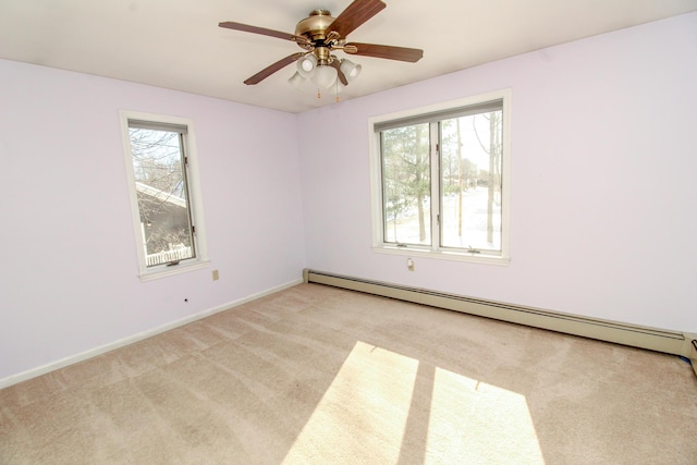 spare room featuring a healthy amount of sunlight, a baseboard radiator, baseboards, and light colored carpet