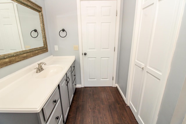 bathroom featuring baseboards, wood finished floors, and vanity