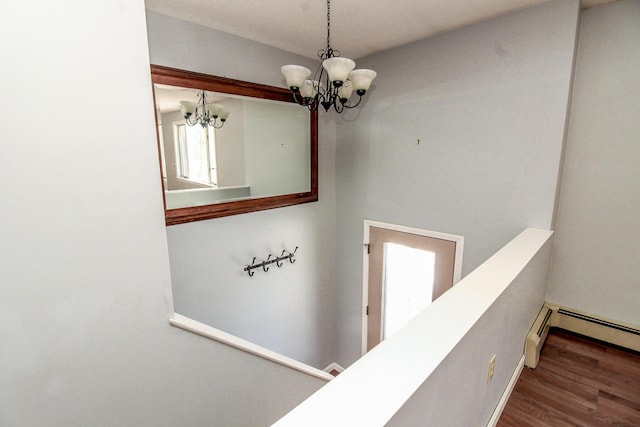 corridor featuring a chandelier, dark wood-style flooring, and an upstairs landing