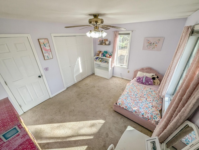 bedroom featuring light carpet, ceiling fan, baseboards, and a closet