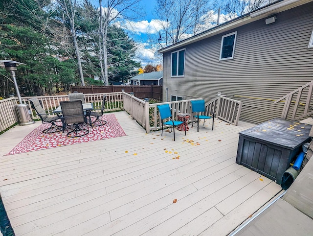 deck with outdoor dining space and fence