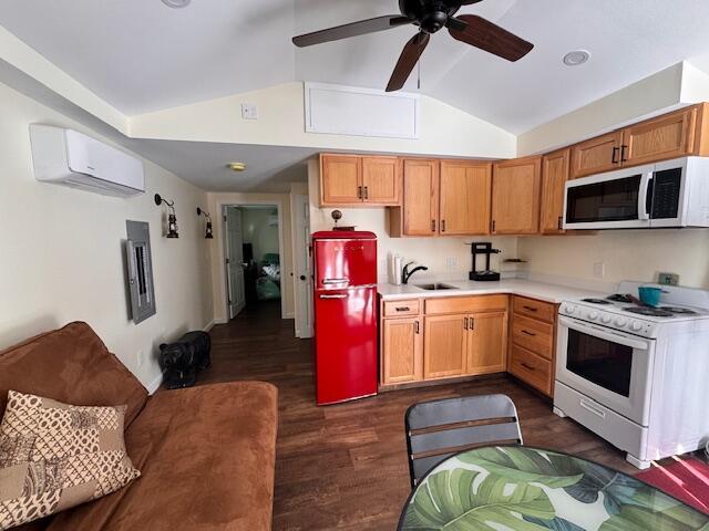 kitchen featuring lofted ceiling, a wall unit AC, dark wood-style flooring, white range with gas cooktop, and light countertops