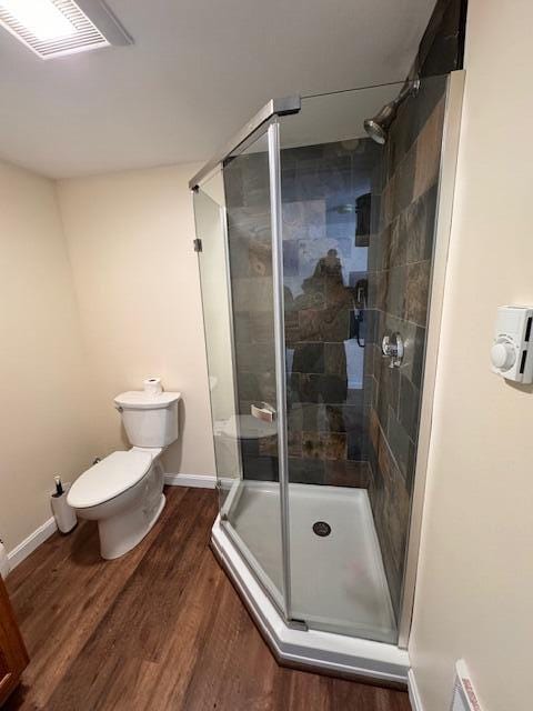 full bathroom featuring baseboards, visible vents, toilet, wood finished floors, and a shower stall