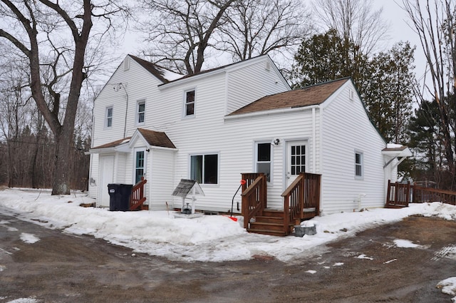 view of snow covered back of property