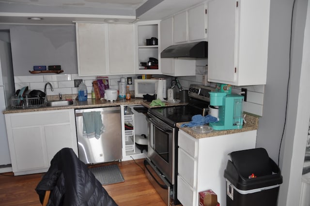 kitchen with under cabinet range hood, backsplash, stainless steel appliances, and open shelves