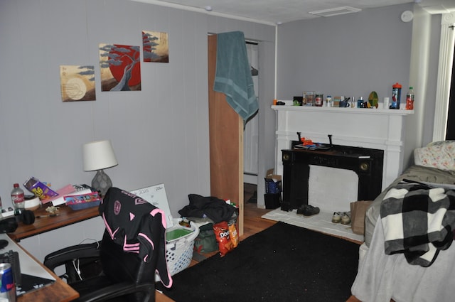 bedroom featuring visible vents, a fireplace, and wood finished floors