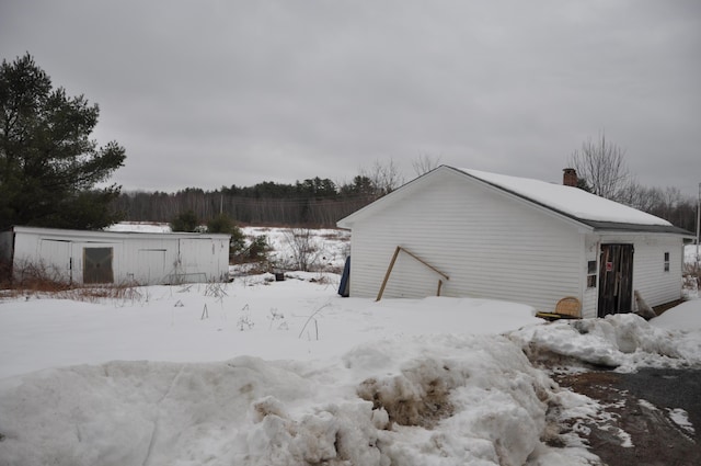 snow covered property with a chimney
