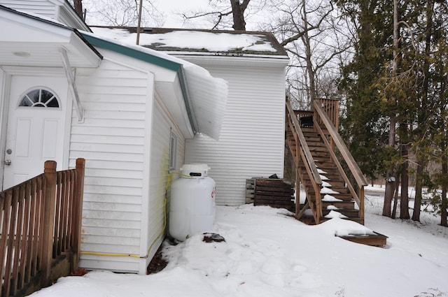snow covered property with stairs