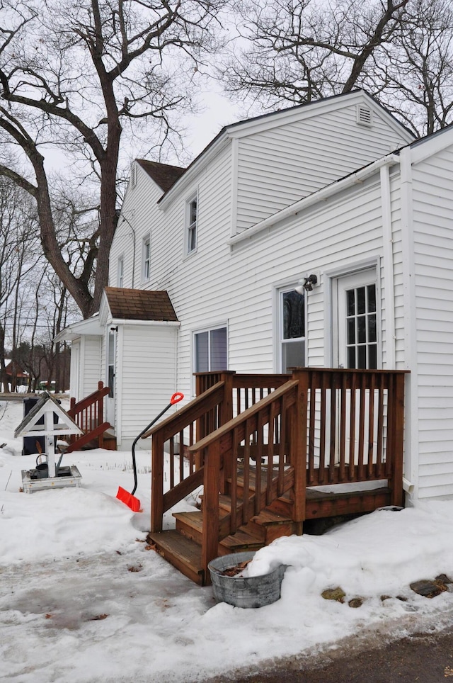 snow covered property featuring an outbuilding