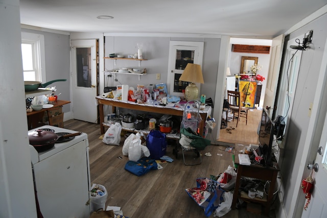 kitchen with open shelves, wood finished floors, and washer / dryer