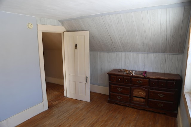 additional living space featuring dark wood-style flooring and vaulted ceiling