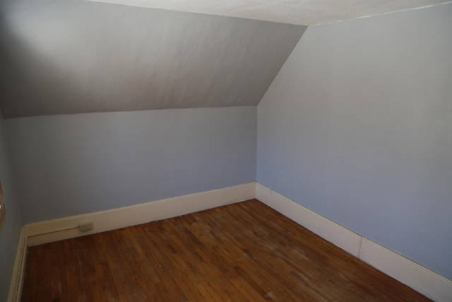 bonus room with lofted ceiling, dark wood finished floors, and baseboards