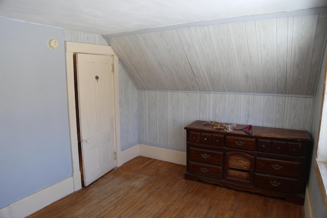 additional living space featuring lofted ceiling, dark wood finished floors, and baseboards