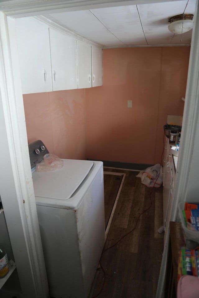 clothes washing area with cabinet space, washer / clothes dryer, and dark wood-style flooring