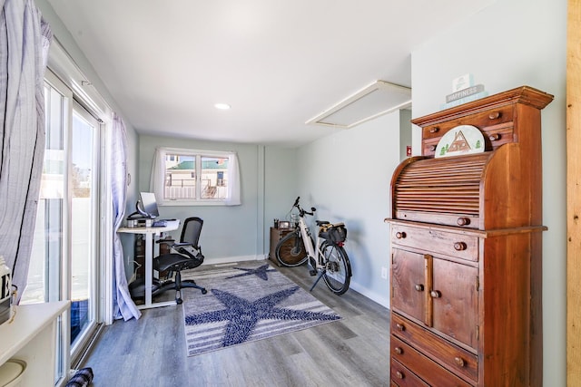 home office with wood finished floors, attic access, and baseboards