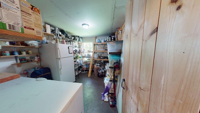 kitchen with light brown cabinets, concrete floors, light countertops, freestanding refrigerator, and open shelves