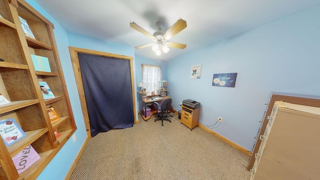 office space featuring a ceiling fan, light carpet, and baseboards